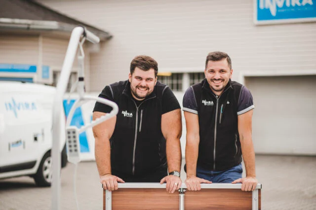 The founders with a bed in front of the Invira headquarters